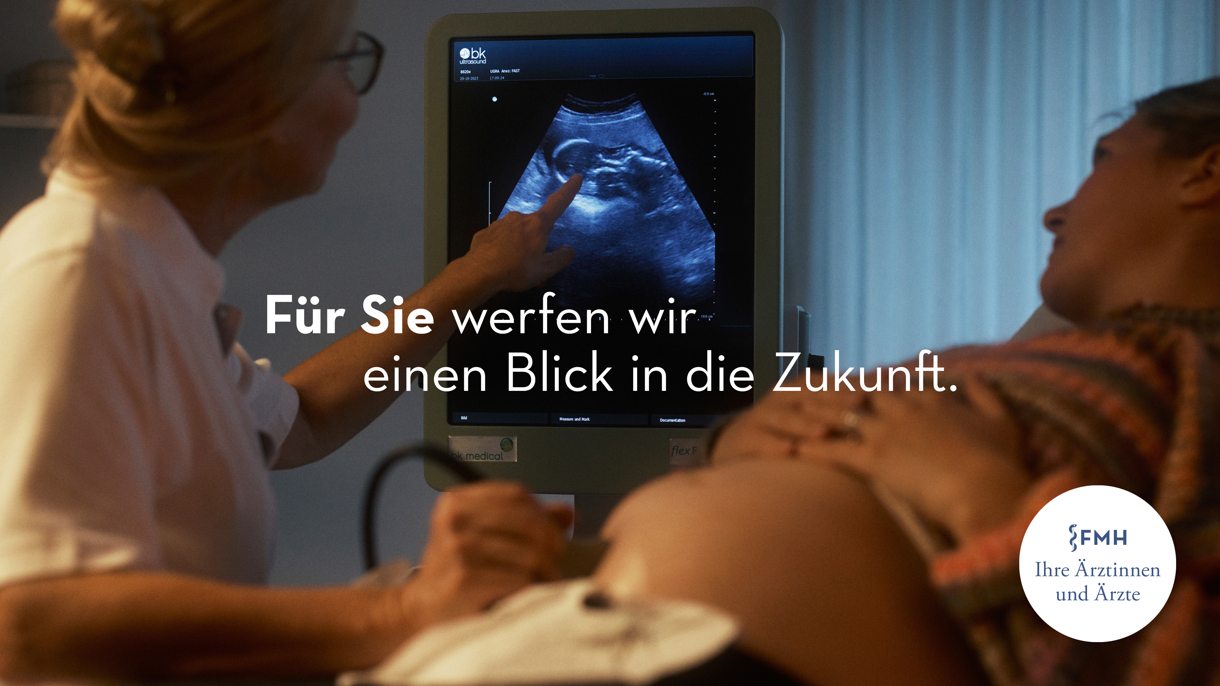 a woman and a doctor looking at an ultrasound machine monitor