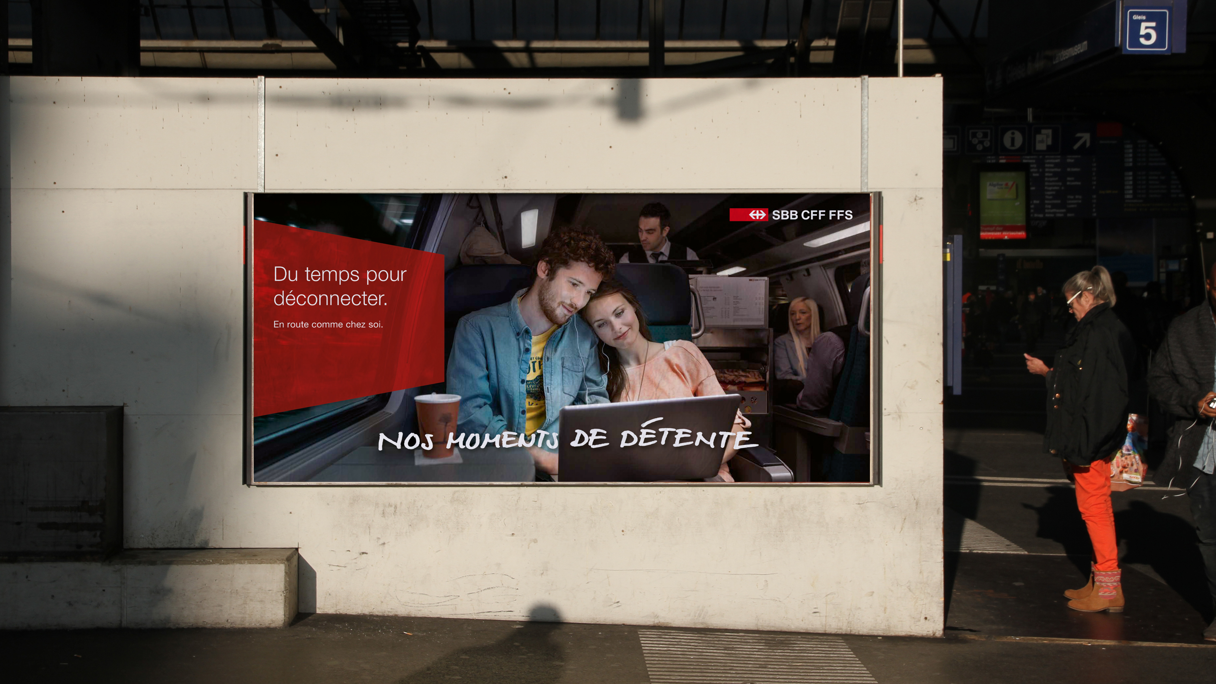 A couple on a train with their heads on each other looking at a laptop